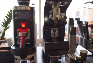 Commercial automatic coffee grinders and espresso equipment setup in a modern cafe